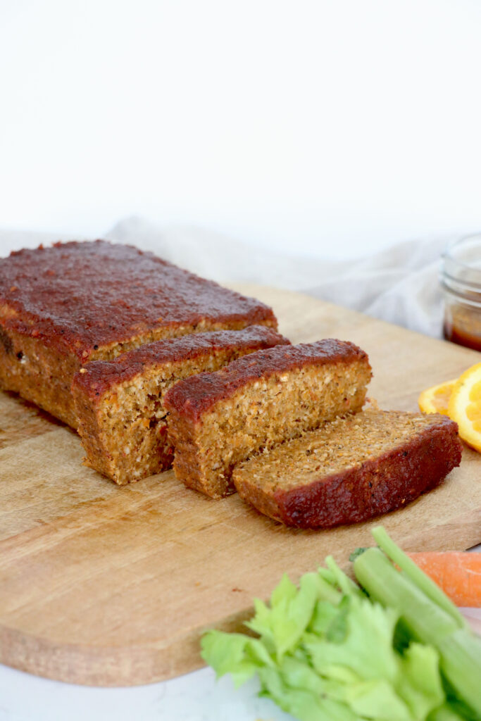 Lentil loaf cut into slices on cutting board.