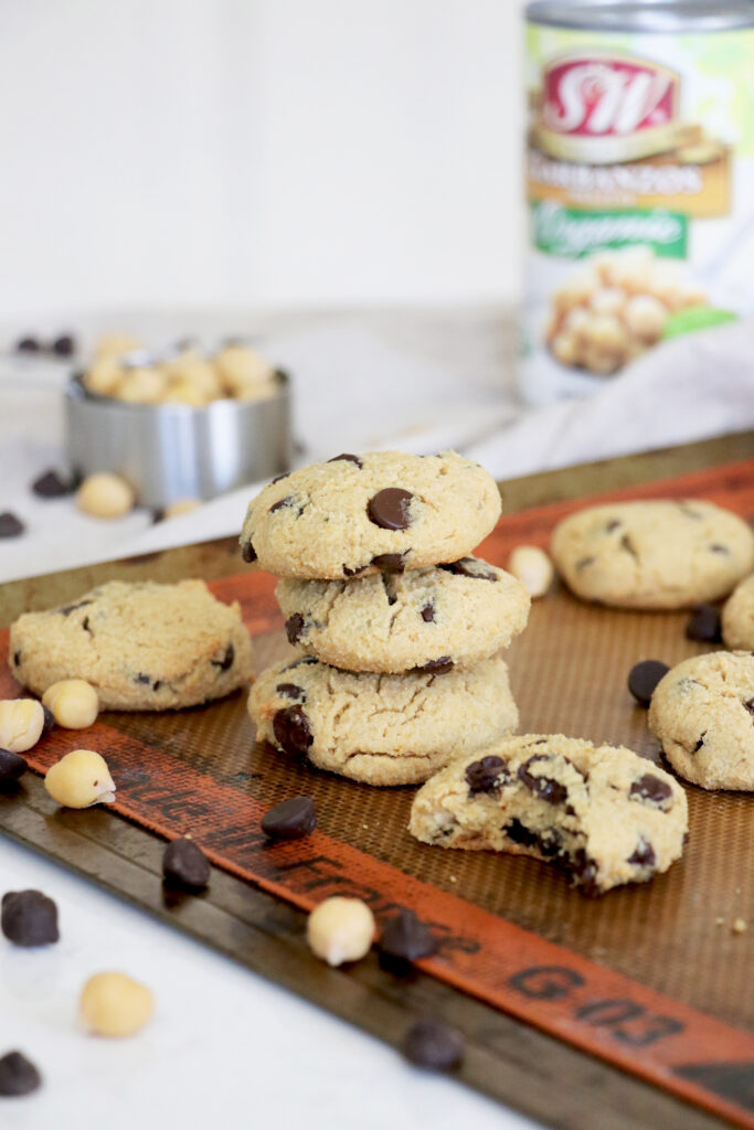 S&W chickpea chocolate chip cookies stacked over baking sheet.