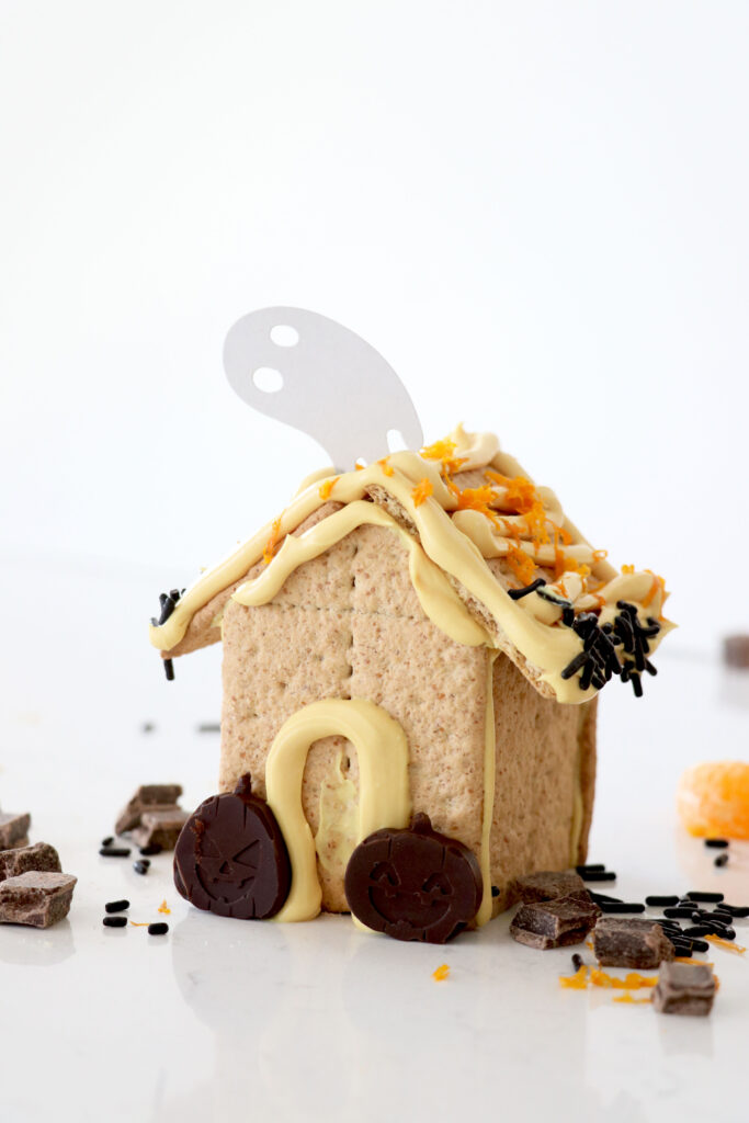 Edible haunted houses with homemade orange icing and orange chocolate pumpkins.