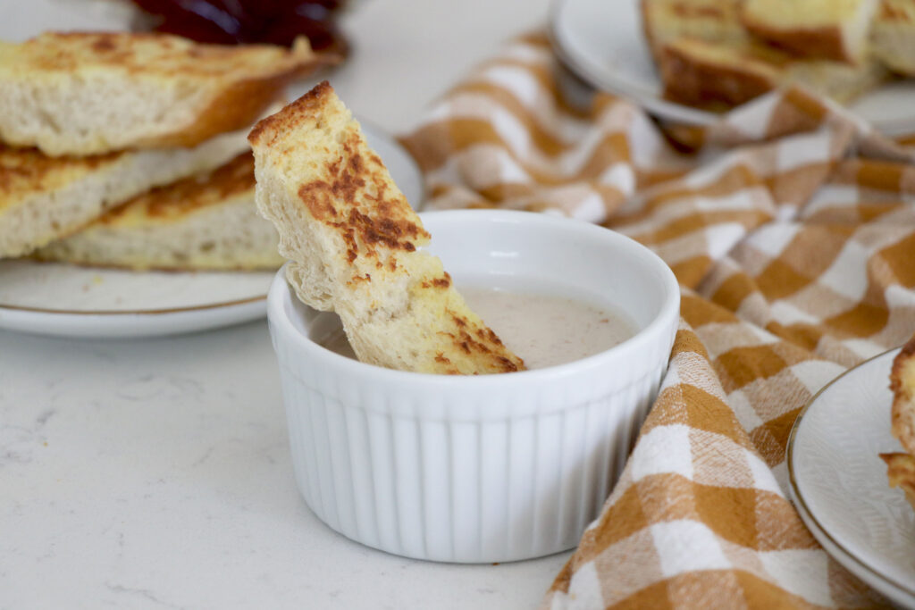 French toast stick being dipped in yogurt