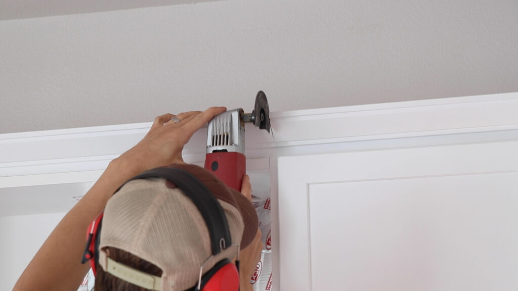 Man using oscillating saw to cut kitchen moulding