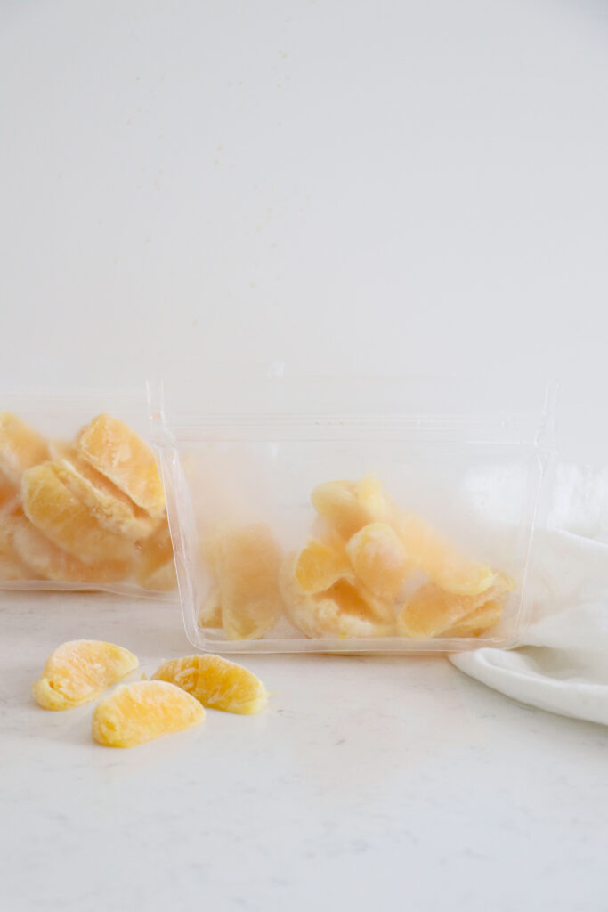 Orange slices in two clear bags and some on the table.