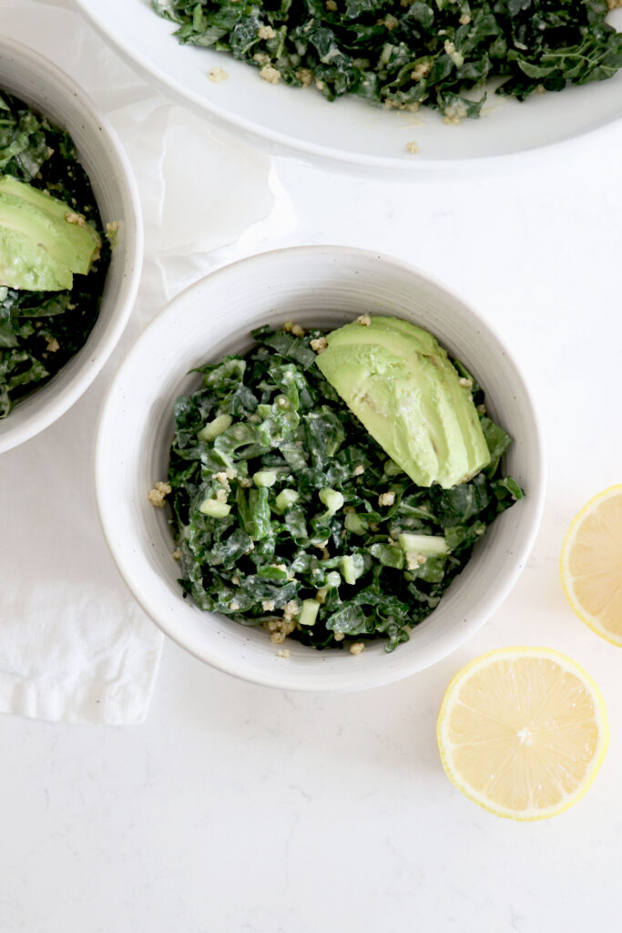 bowls of Salad with sliced avocado and sliced lemon.