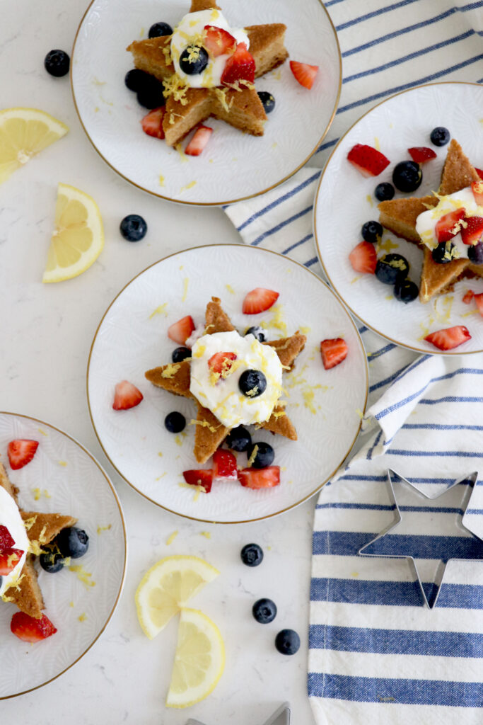 Plates with star cakes topped with yogurt and berries.