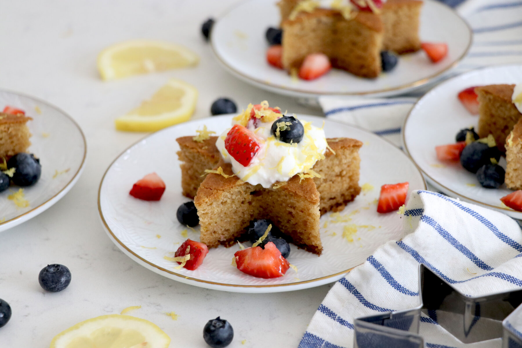 White plate with star cakes and topped with sliced fruit.