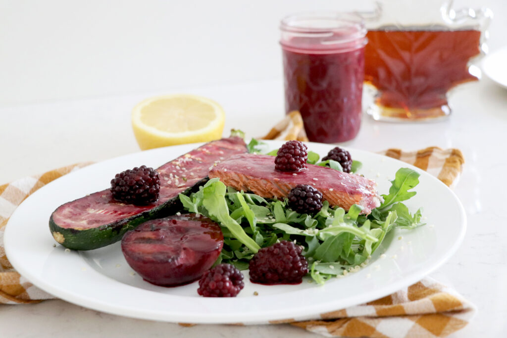Plate with blackberry marinated salmon, zucchini and plums