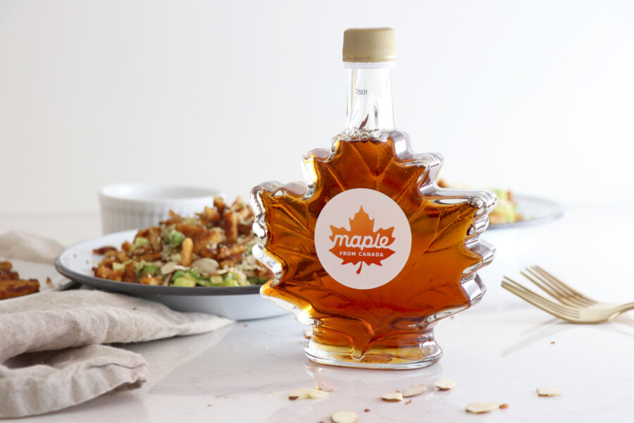 Maple From Canada syrup bottle with salad in the background.