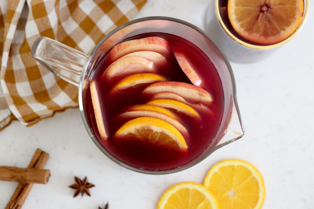 birds eye view of pitcher with orange apple sangria that has orange and apple slices at the top.