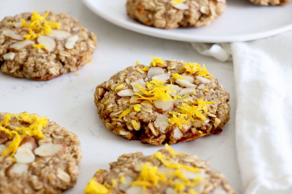 Breakfast cookies on counter with orange zest and almonds on top.