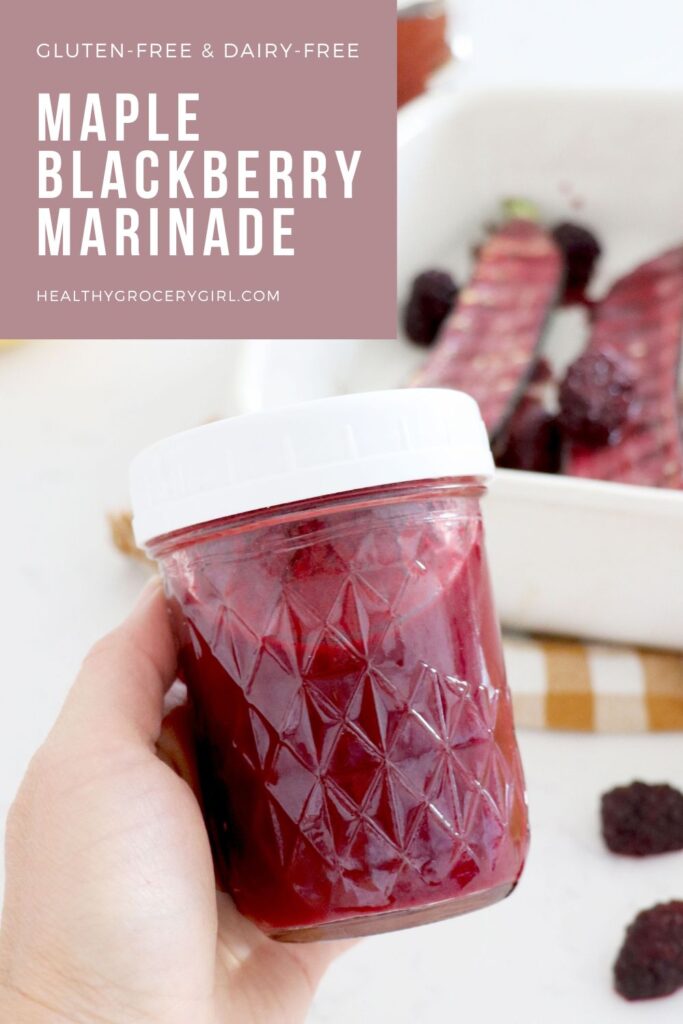 Hand holding jar of maple blackberry marinade