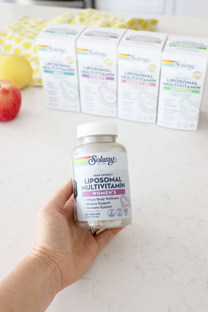 Hand holding liposomal women's multivitamin.