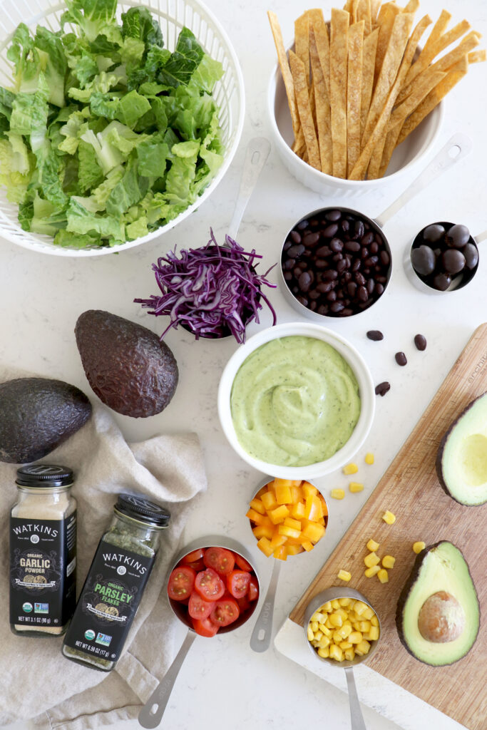 Taco salad spices and ingredients. Avocado ranch, romaine and veggies.